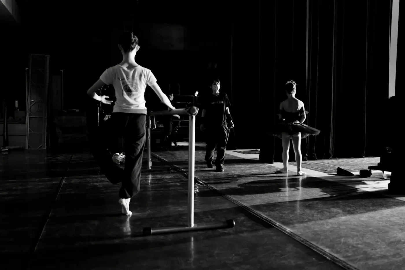 Dancers in practice clothes working at portable barres in a studio